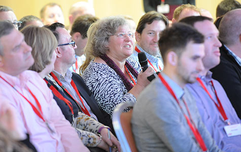 Photograph of a woman asking question at an AON corporate event